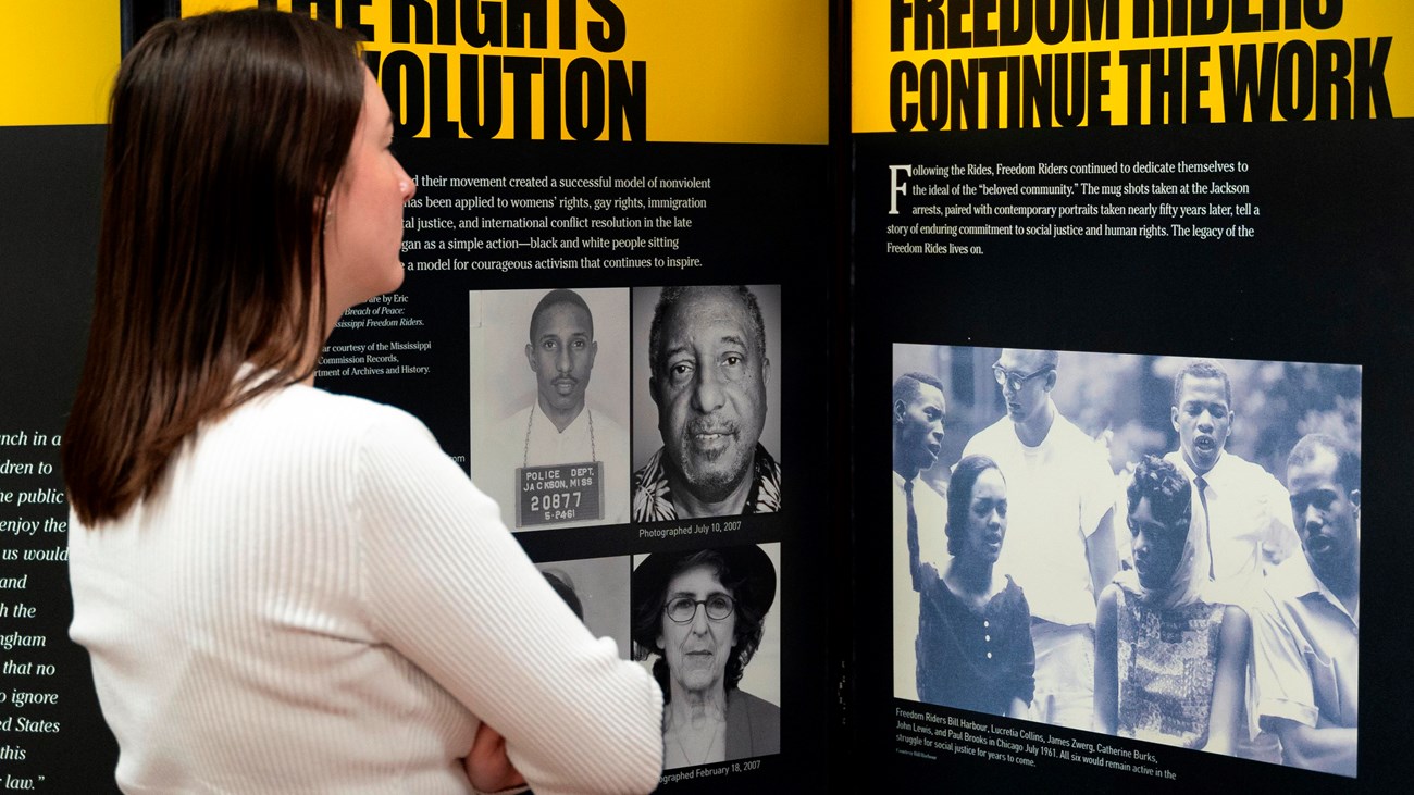 A woman studies a photo of people marching.