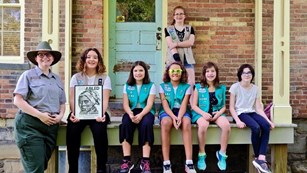 Ranger standing next to a group of Girl Scouts