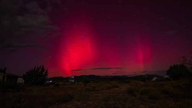 The sky is lit up with red, purple, and slight bit of green during an aurora event.