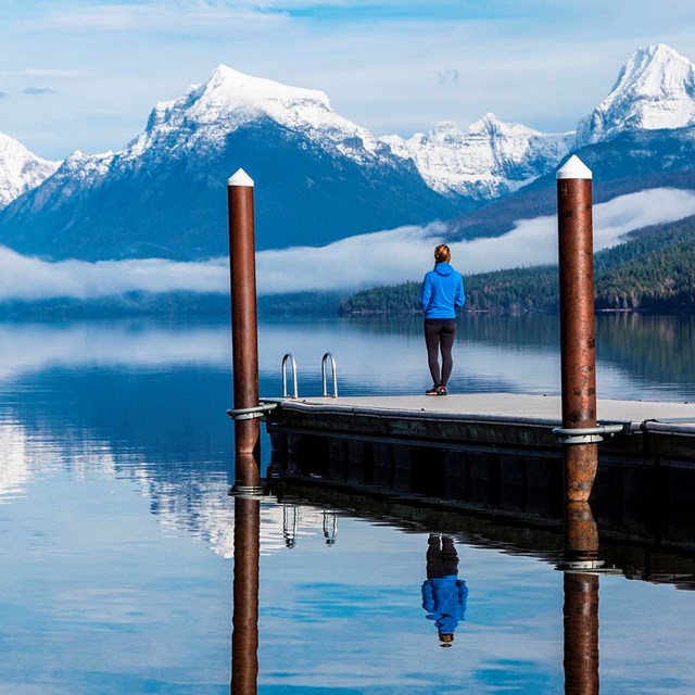 Visitor stands on public dock and looks at mountains