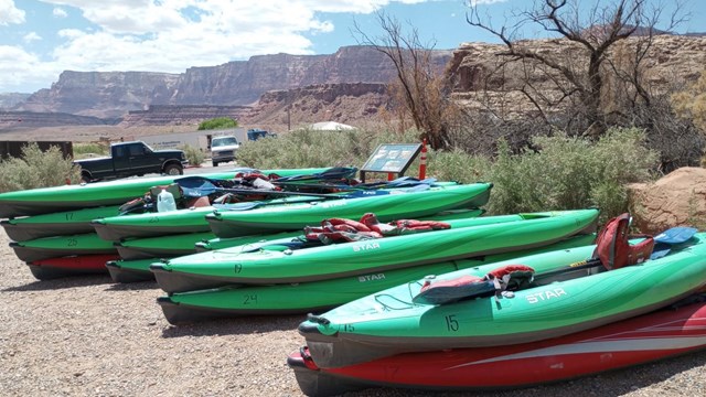 A stack of kayaks next to a launch ramp