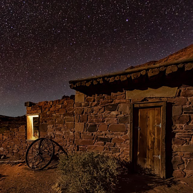 Stone and wooden building at night with a starry sky