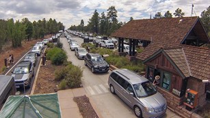 5 long lines of cars waiting to enter the park at the entrance station.
