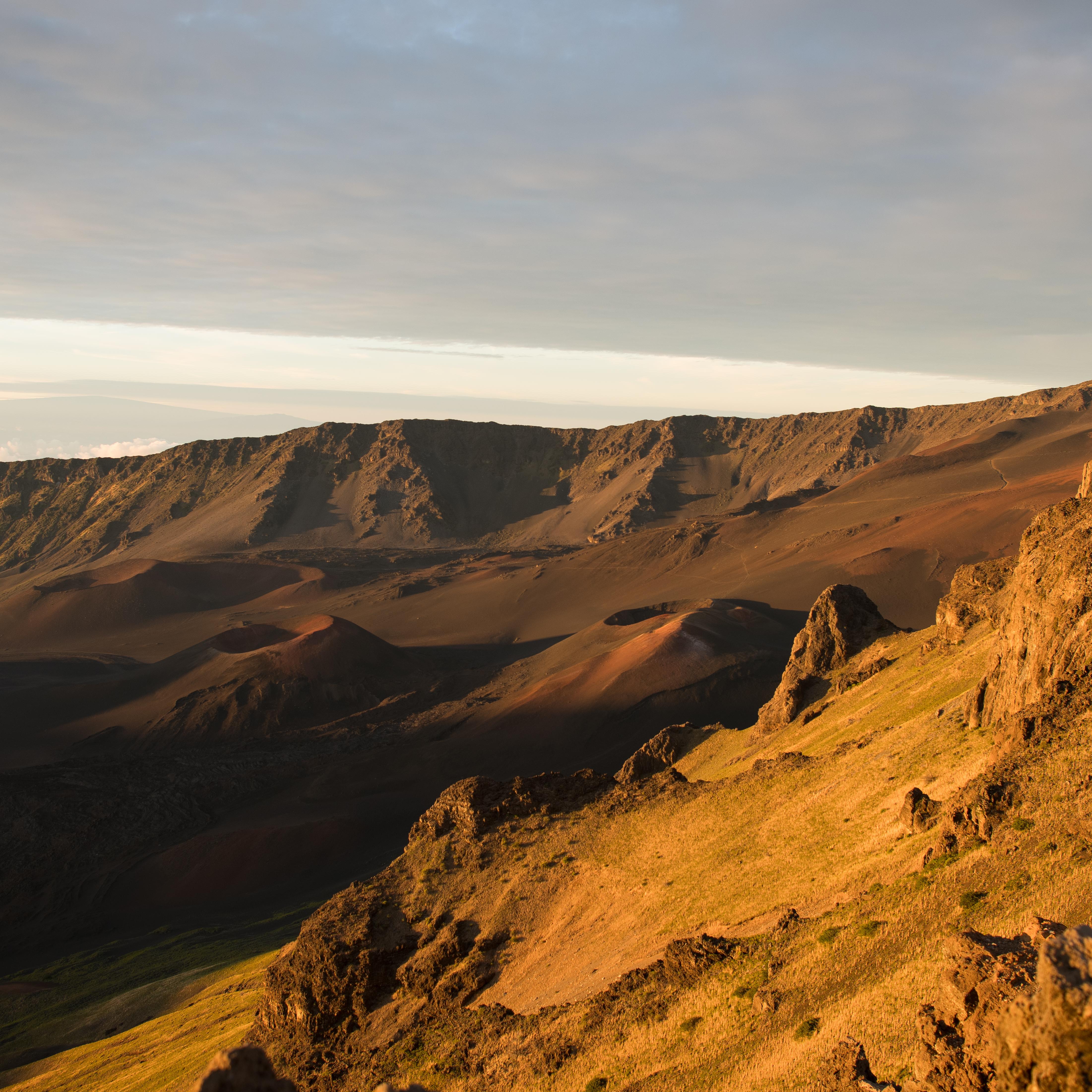 Clouds creep into an expansive volcanic crater