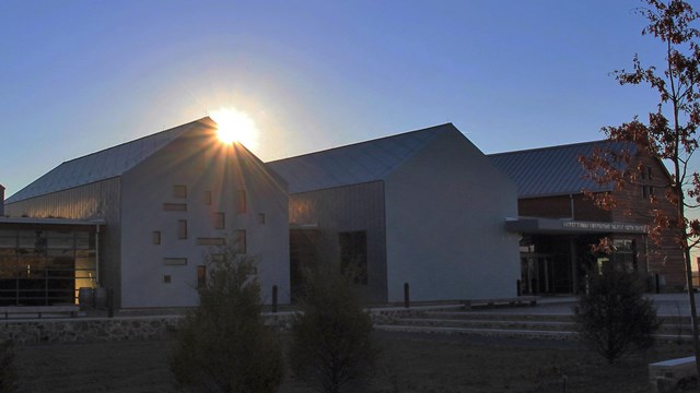 Sun rising above one of the rooflines of the Harriet Tubman Underground Railroad Visitor Center
