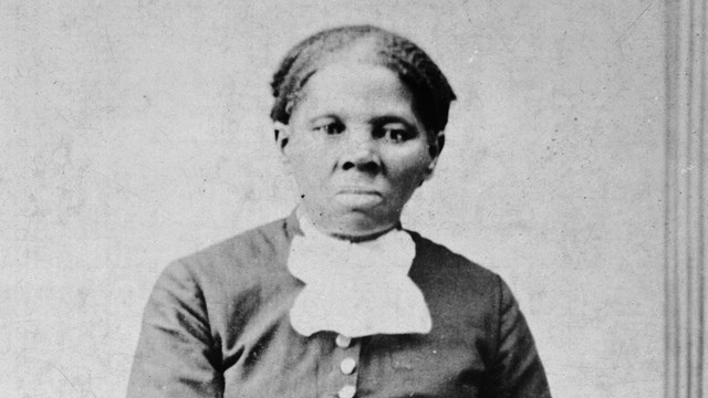 1871 Image of Harriet Tubman looking directly at the camera with folded hands on a chair back