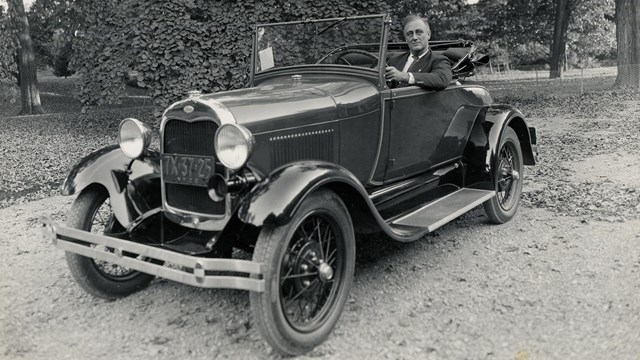 FDR driving an open top automobile on his property. 