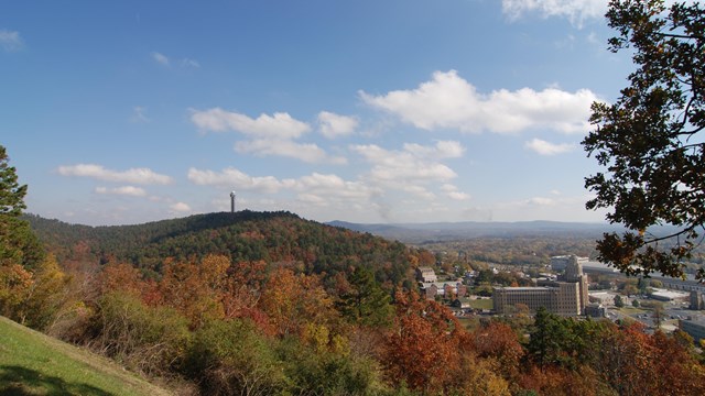 A view from West Mountain overlook looking across rolling hills with fall colored leaves.