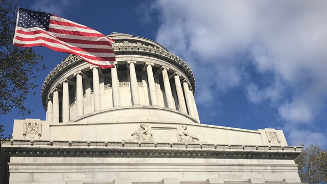 U.S. flag flying near a classical-style memorial dome