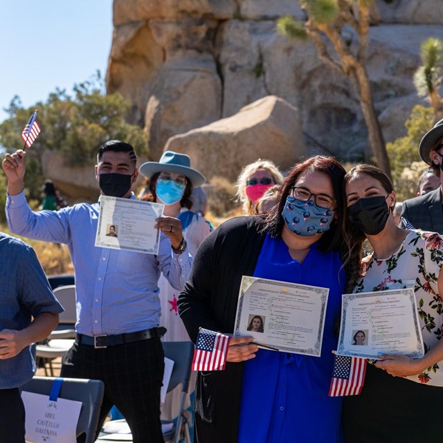 A group of people holding up certificates 