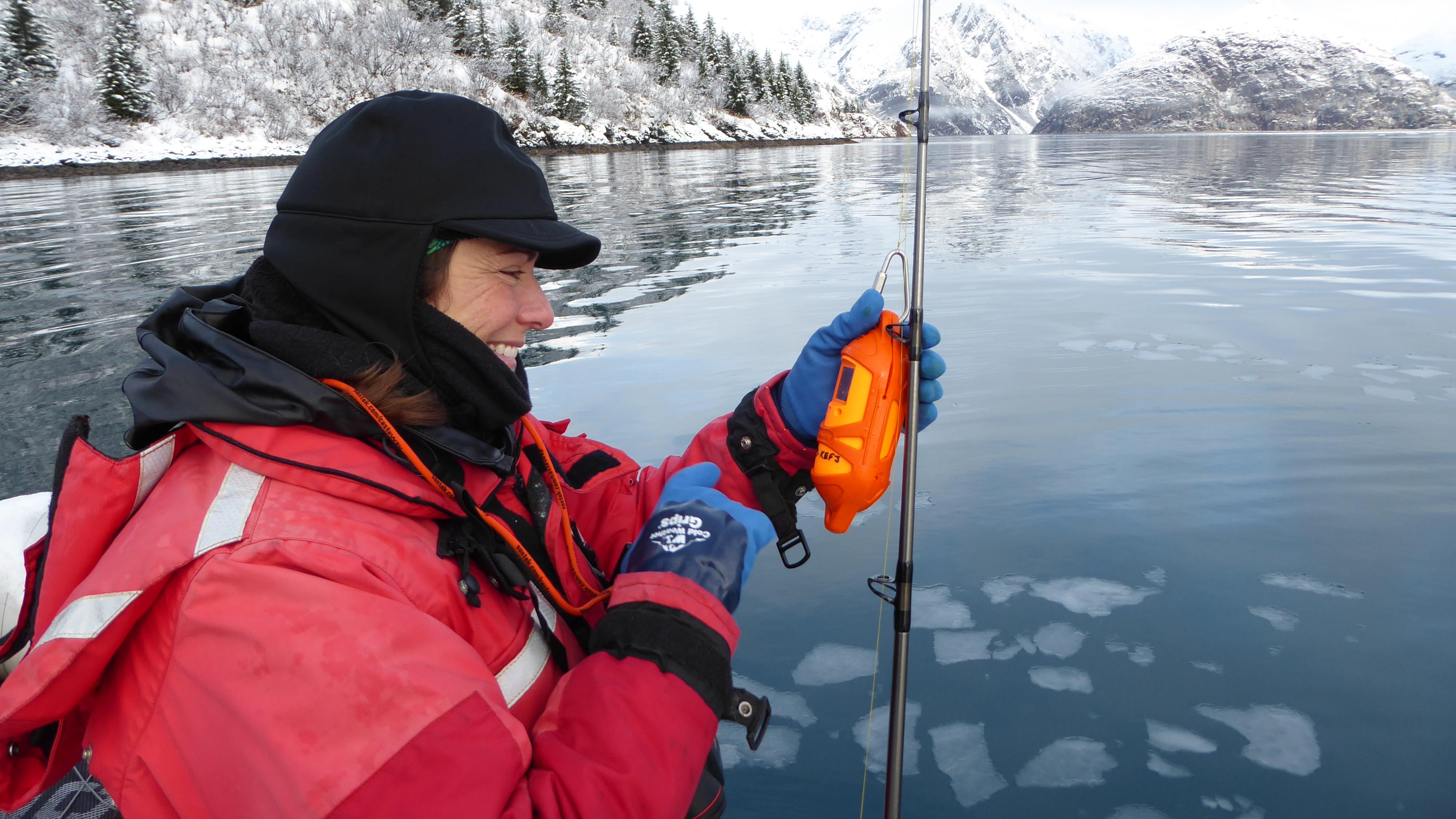 A park scientist holds up a device attached to a fishing pole