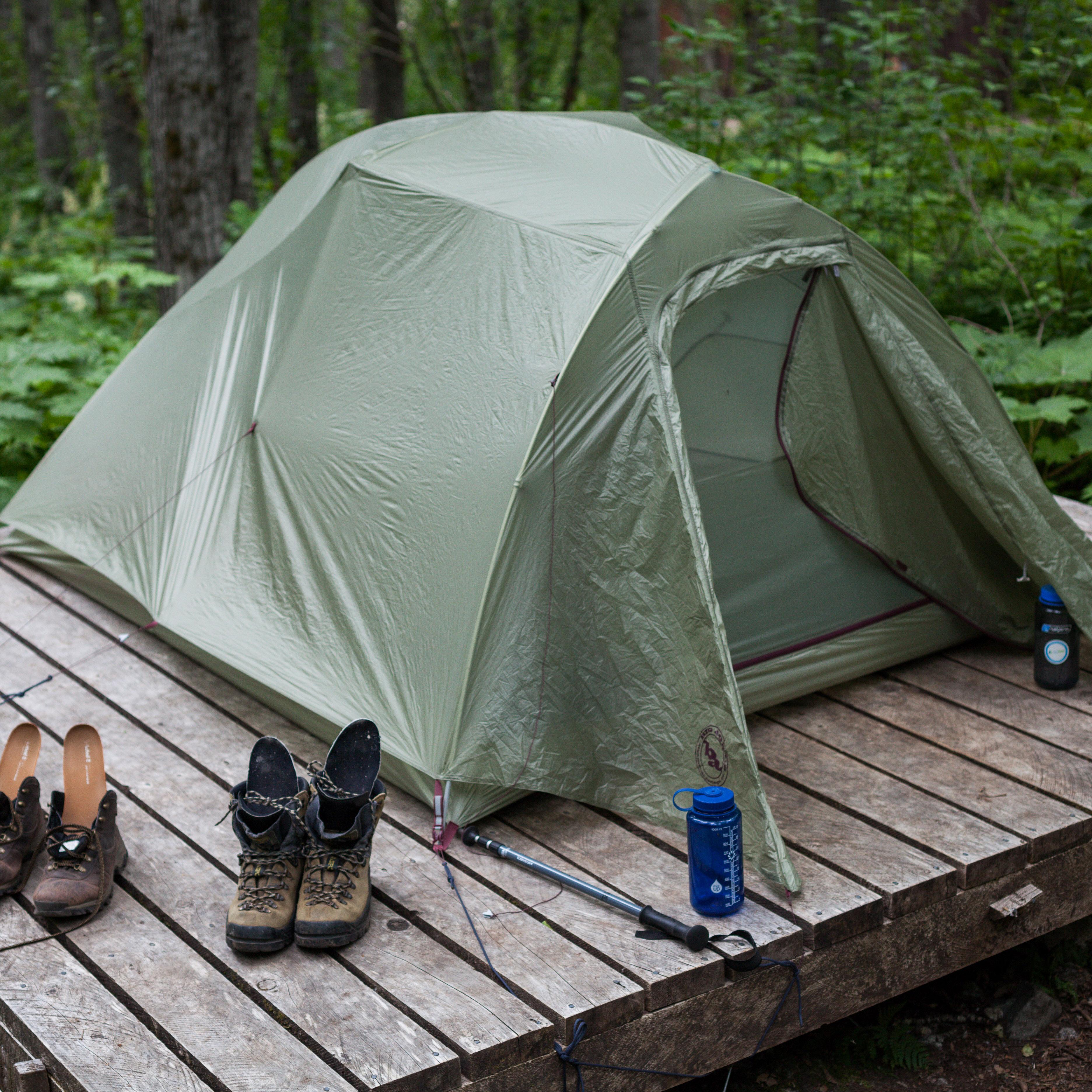 a tent on a wooden platform in the forest