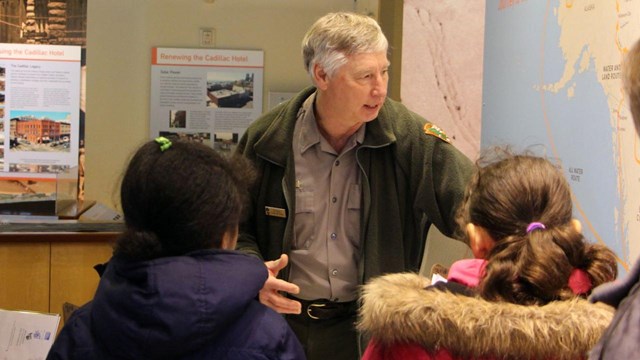 ranger discusses wall map with students in foreground