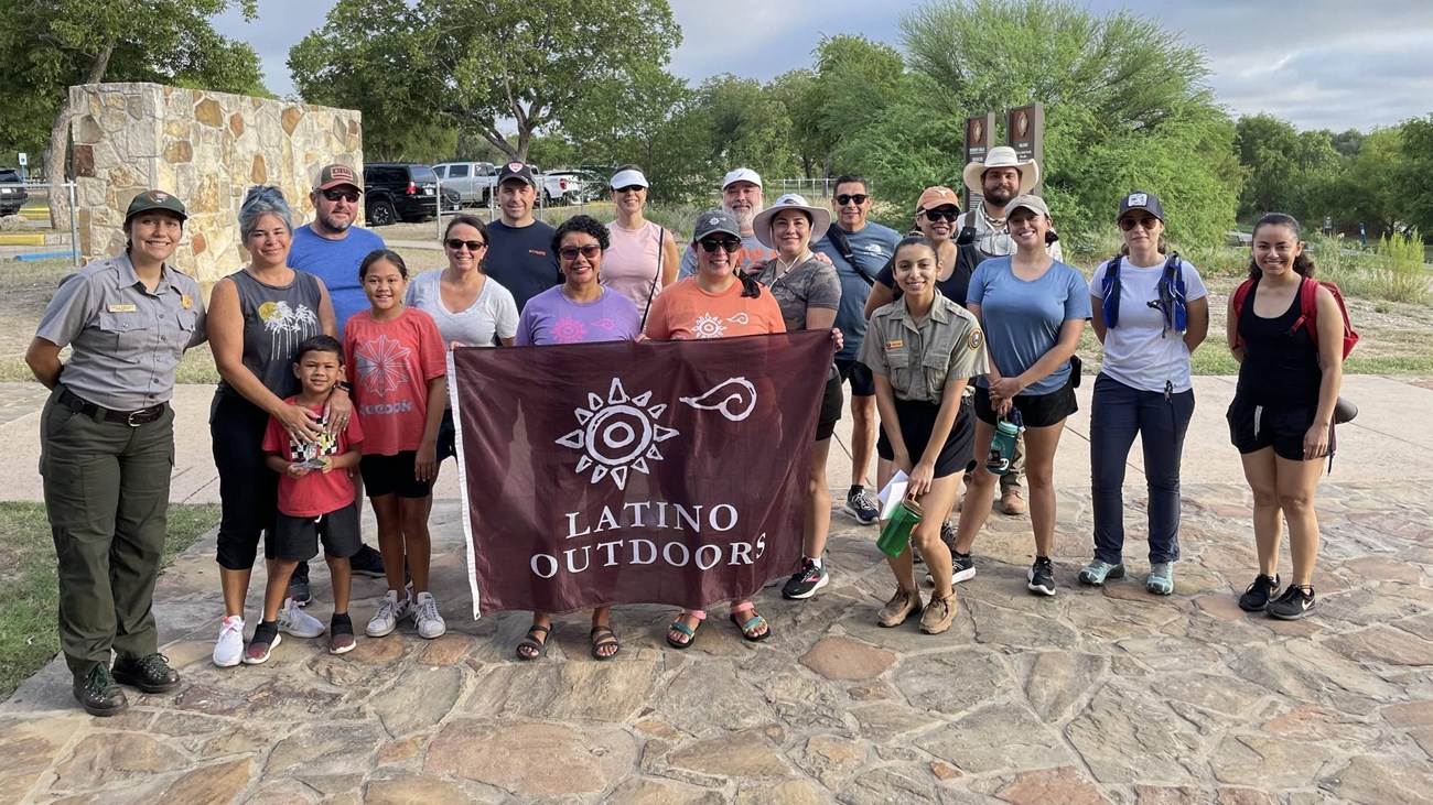 Group of people holding a sign saying "Latino Outdoors" 