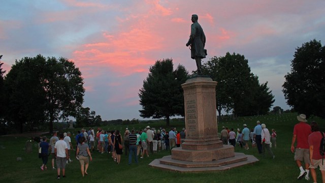 Visitors near memorial during sunset time