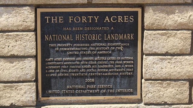 A black and gold plaque designating The Forty Acres as a National Historic Landmark.