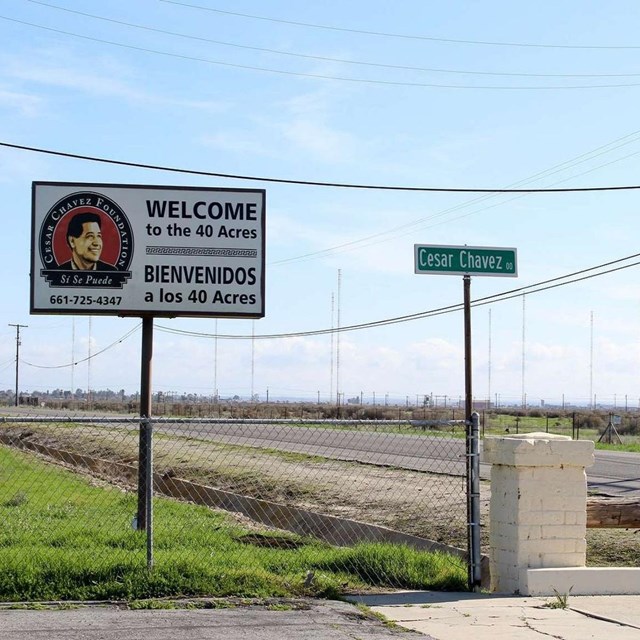 A sign that says Welcome to the 40 Acres next to a Cesar Chavez street sign.