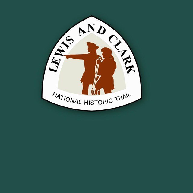 Lewis and Clark Trail Logo on green background. Town explorers look west. One points. 