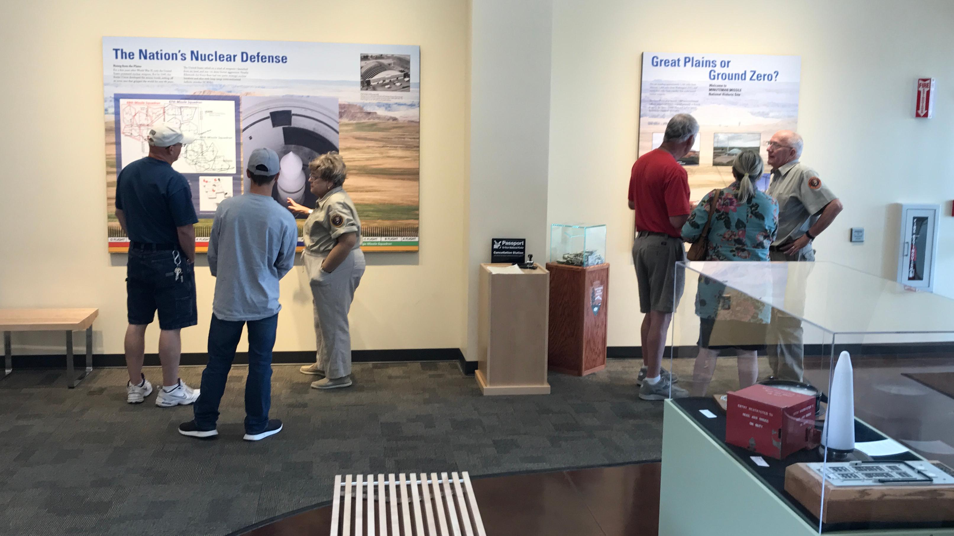 Volunteers interact with small groups of visitors in a lobby