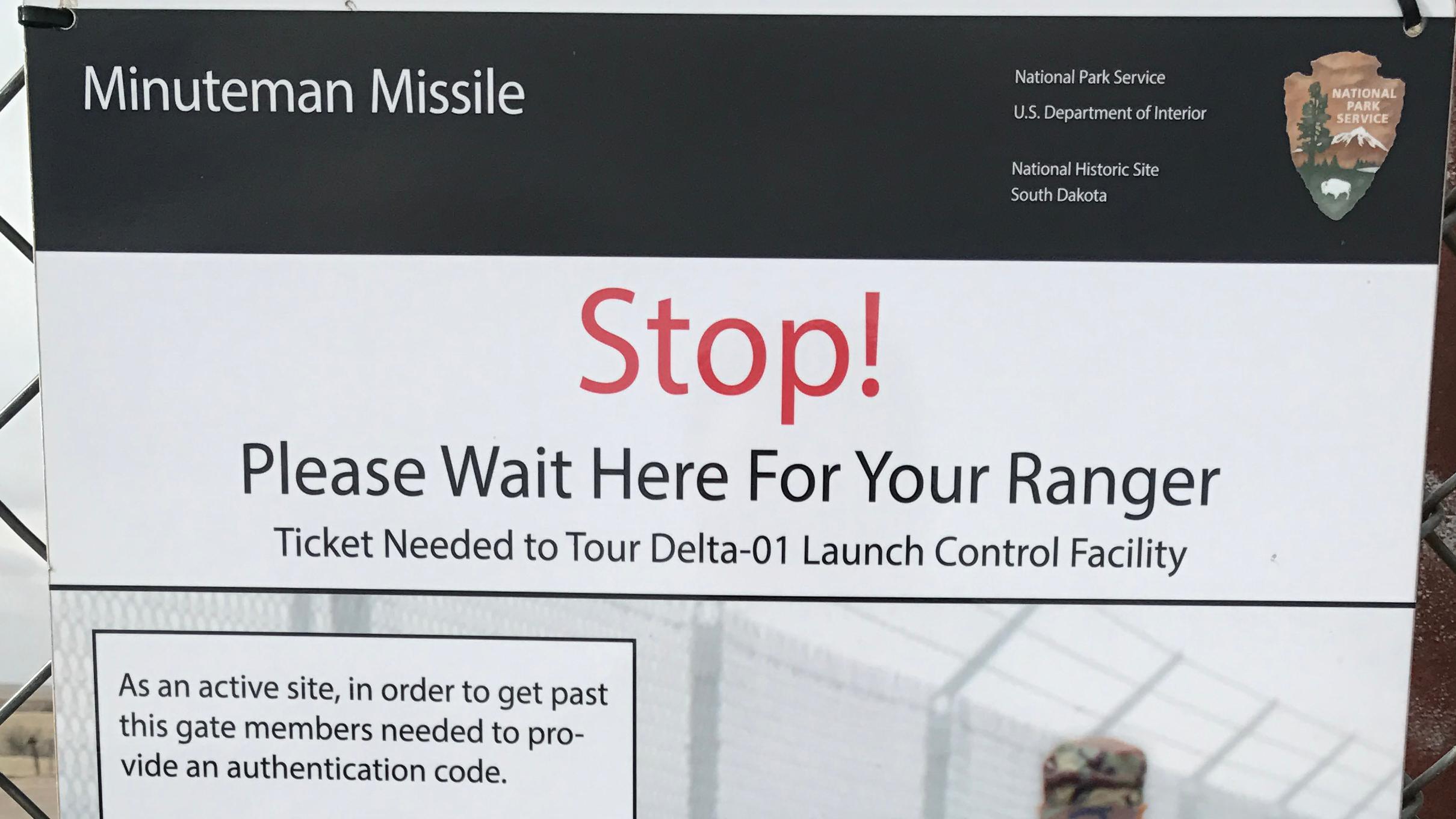 Gate sign with red text that states: Stop!