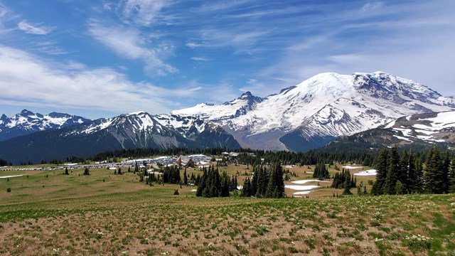 A cloudy view of glaciated Mount Rainier, with Little Tahoma on the left.