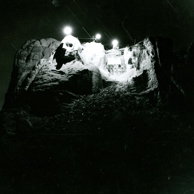 Photo of an attempt in 1939 to illuminate Mount Rushmore from the top of the sculpture.
