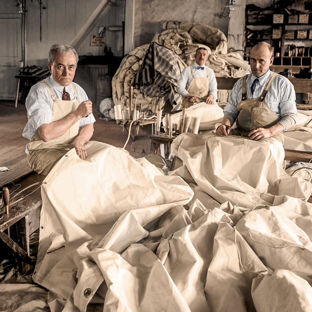 Colorized image of men working in a sail loft
