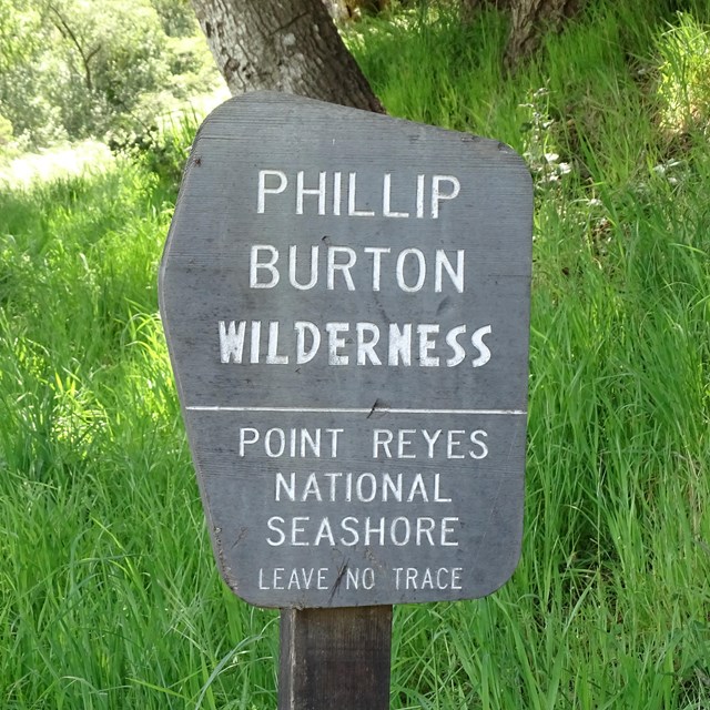 A gray wooden sign with the words 
