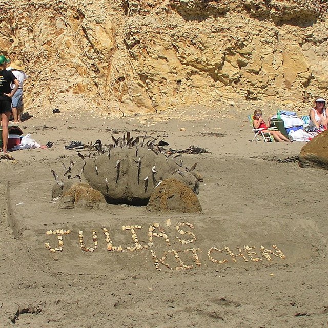 A sand sculpture of a cooked chicken above the words Julia's Kitchen.