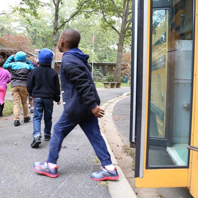 Kids getting off their yellow school bus at the Nature Center