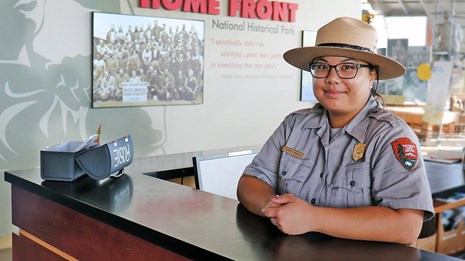 Image of female ranger at the front desk of the visitor center. 