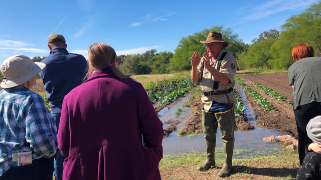 Volunteer demonstrates historic farming practices.
