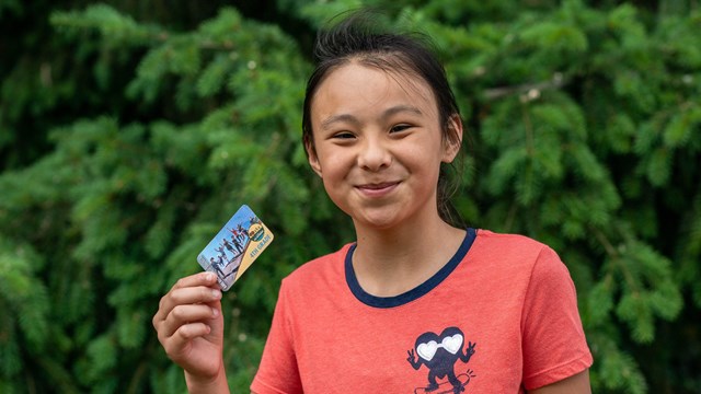 student holds up park entry pass