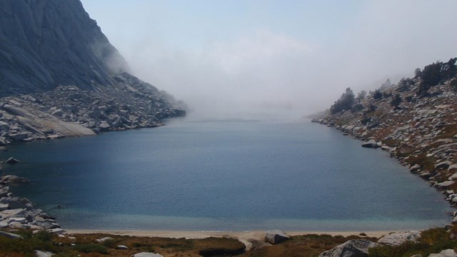 Large lake with rocky shores and far end appears to disappear into clouds