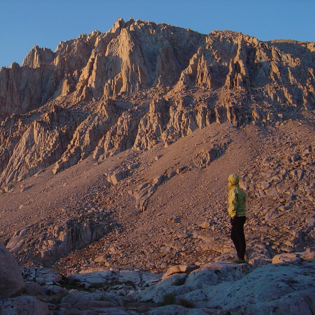 A backpacker looks towards the peak of Mount Whitney. 