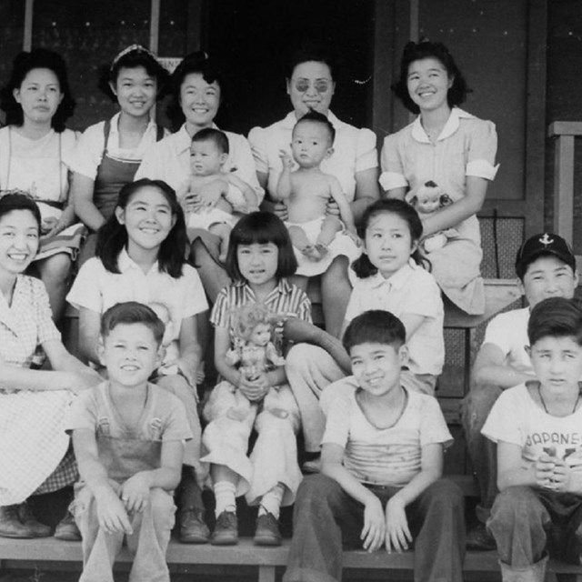Japanese Americans posing in a row of 3 both adults and children.