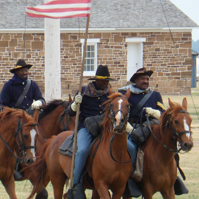 Photo of men on horseback in uniform. 