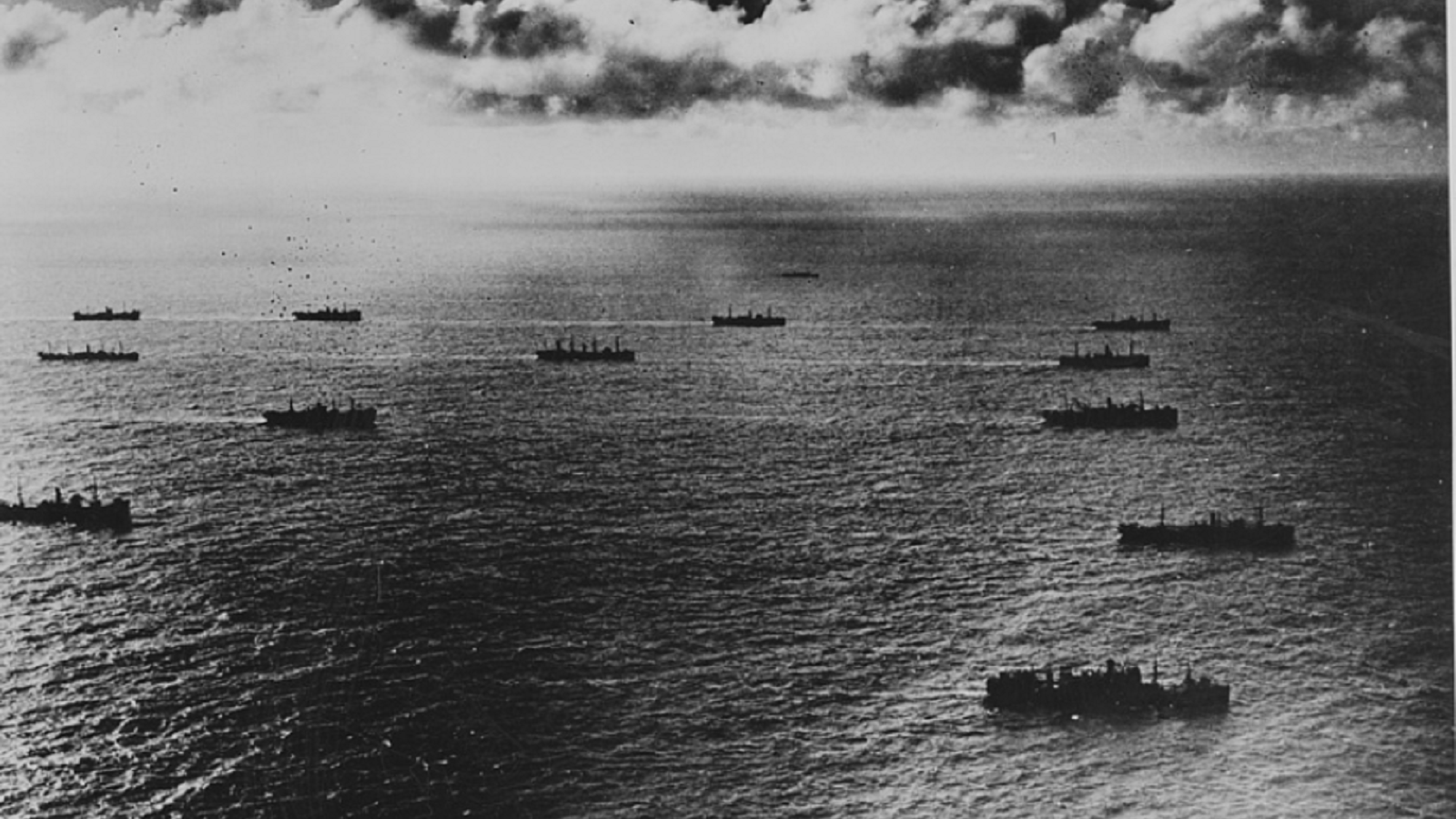 1940s black and white photo depicting several ships on the ocean. 