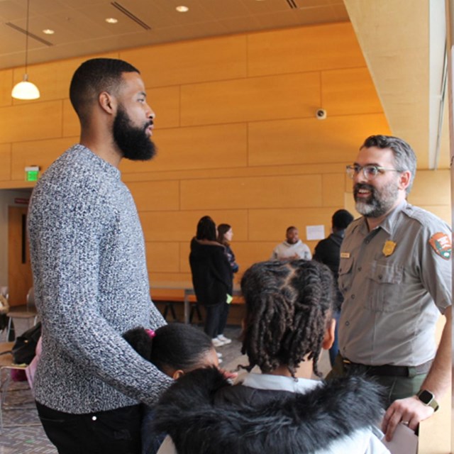 Image of a family talking to a Park Ranger at an in-person program