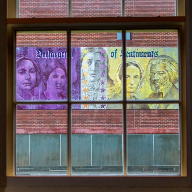 A view looking through the window of the Wesleyan Chapel at the purple and gold mural