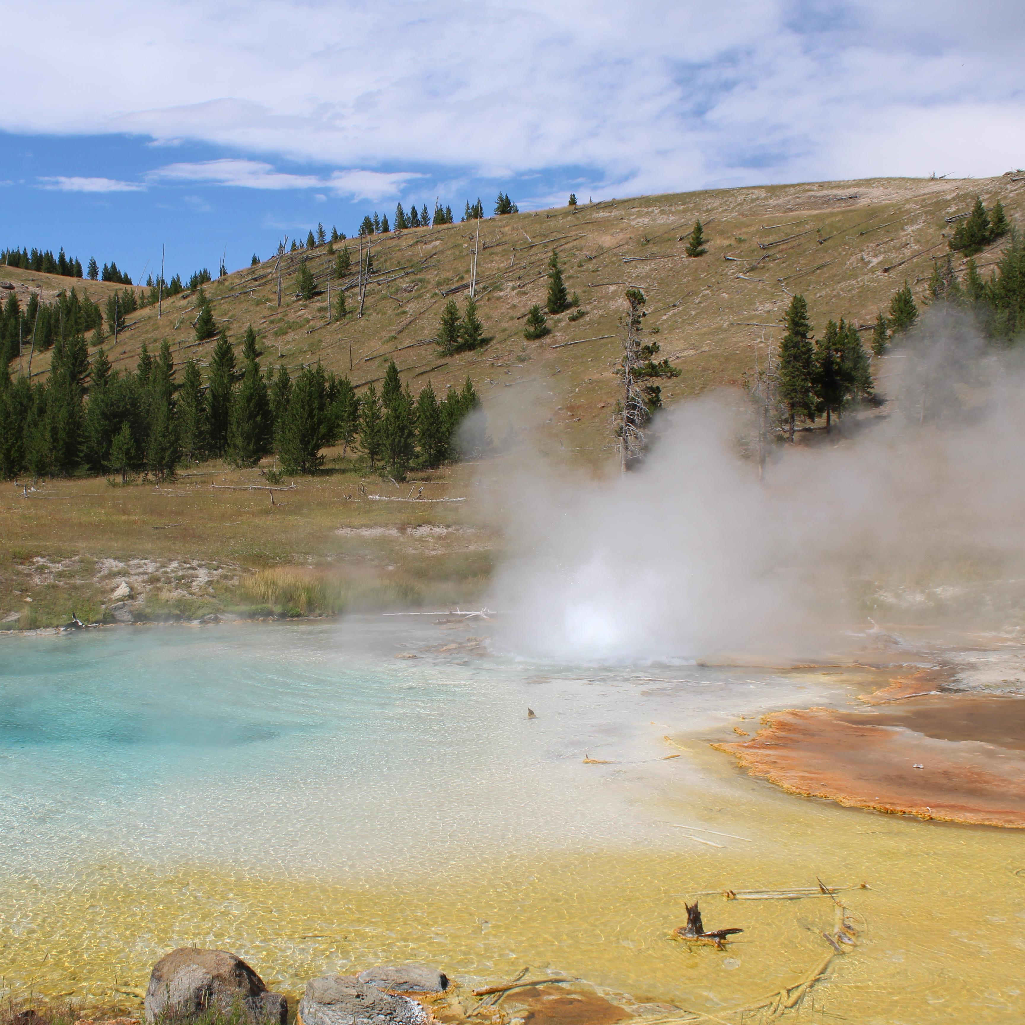 Blue and orange hot spring steams and churns.