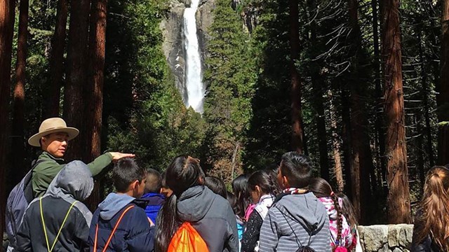 Ranger with a group of students with Lower Yosemite Fall in the background