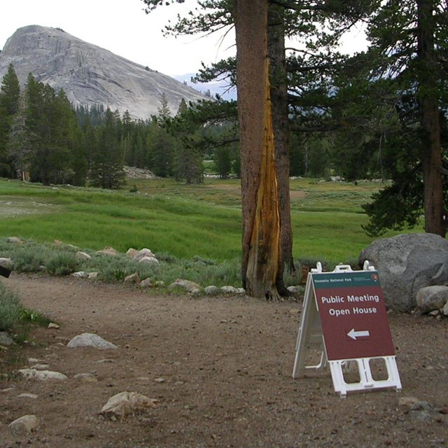 Public meeting sign near Parsons Lodge in Tuolumne Meadows with Lembert Dome in back