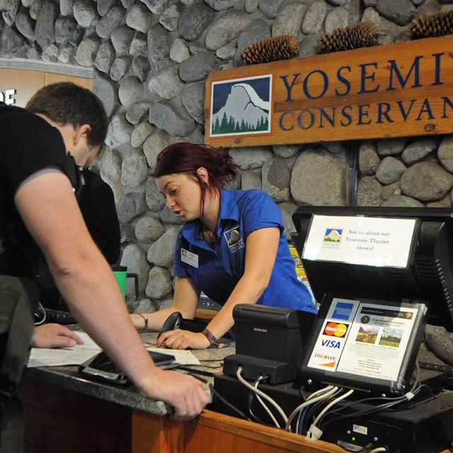 Yosemite Conservancy employee helping a visitor at the Yosemite Valley Visitor Center.