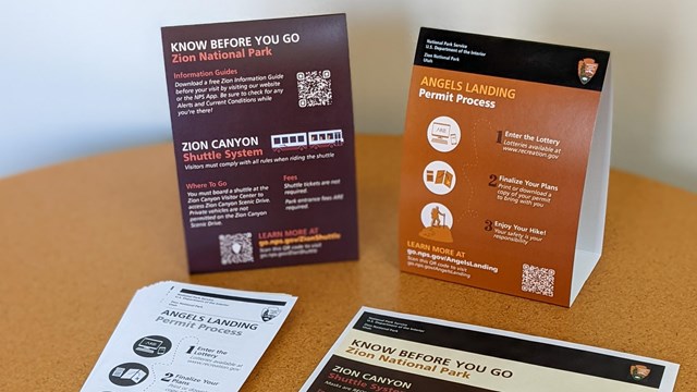 Black and white rack cards and color printed matter with QR codes and information about Zion