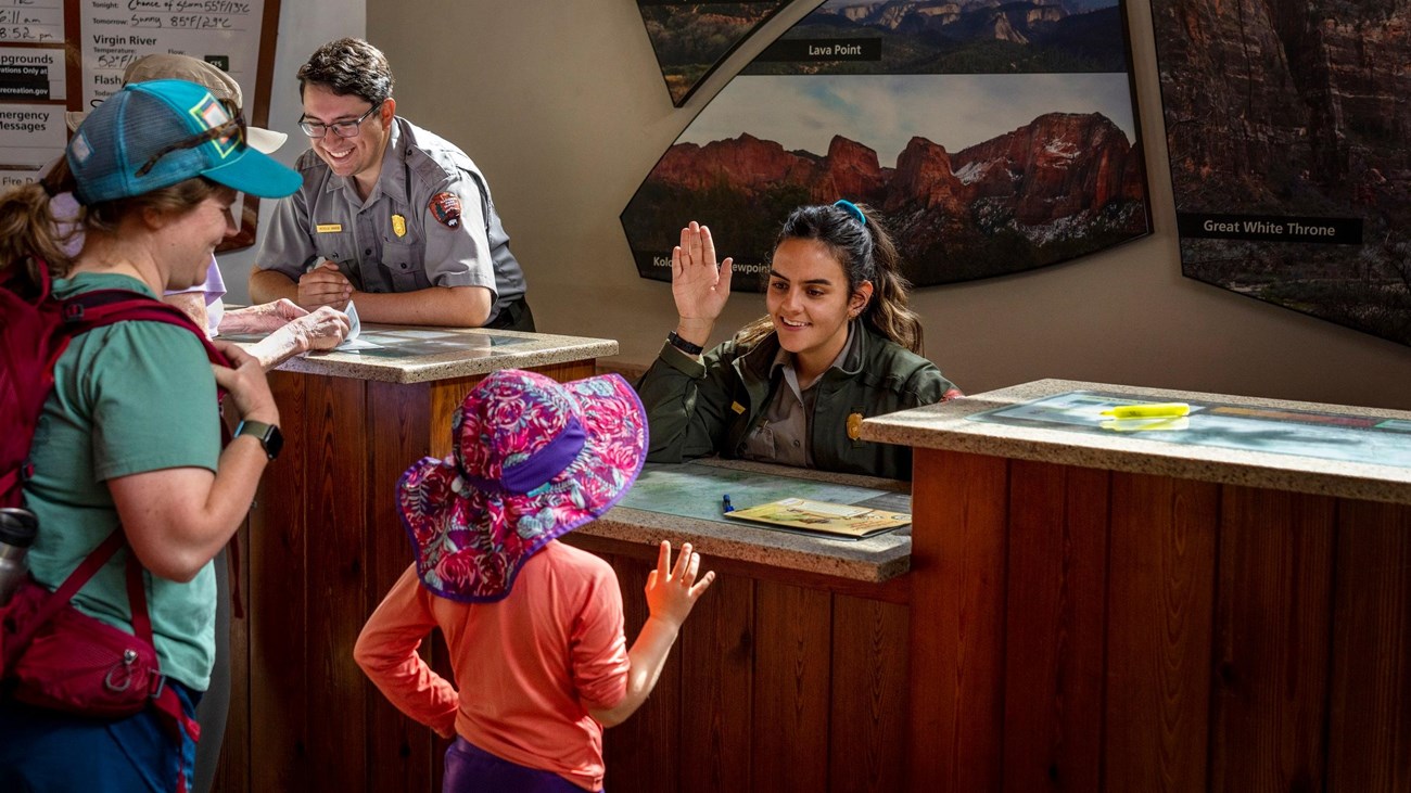 park ranger administering junior ranger pledge at Zion Canyon Visitor Center Desk
