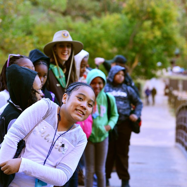 students walking on a bridge over a stream