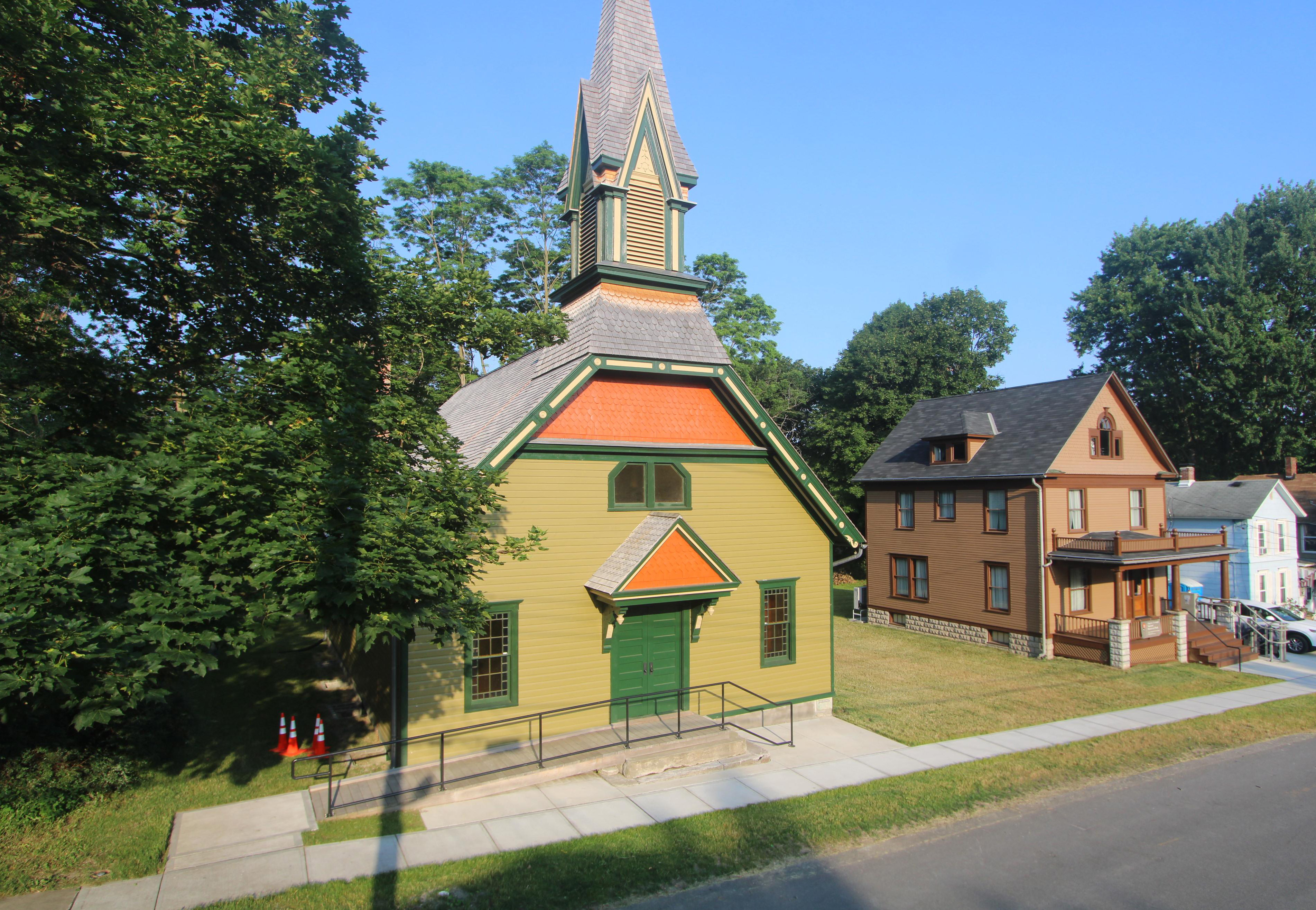 An image of the exterior of a church under construction, with equipment and workers standing outside.