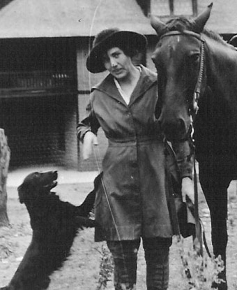 Lillian Erickson Riggs standing between a dog and a horse at Faraway Ranch