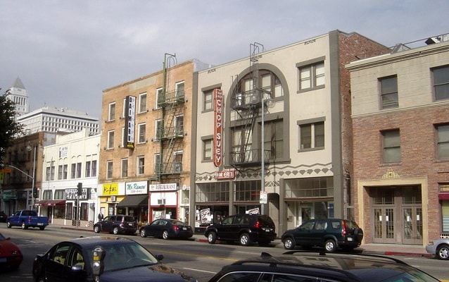 Photo of street with several three-story buildings in background. 